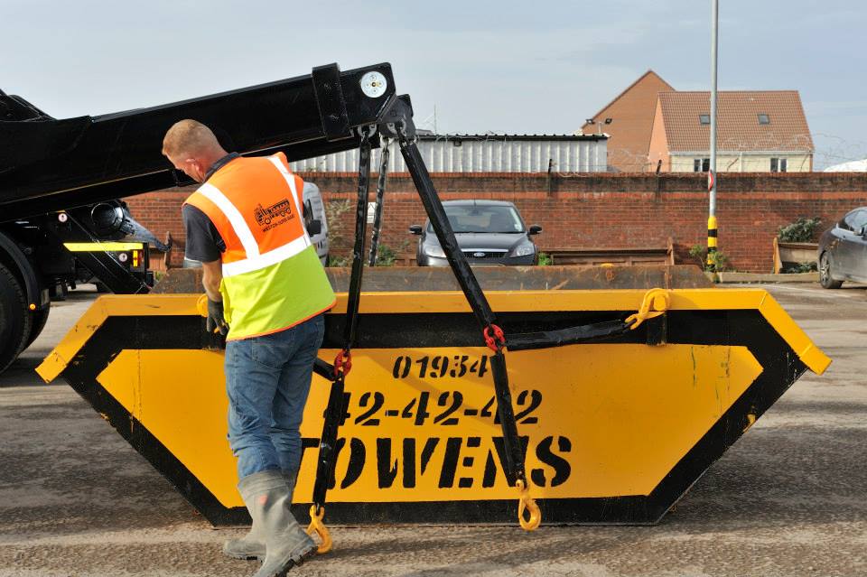 A Towens yellow and black skip being unloaded.