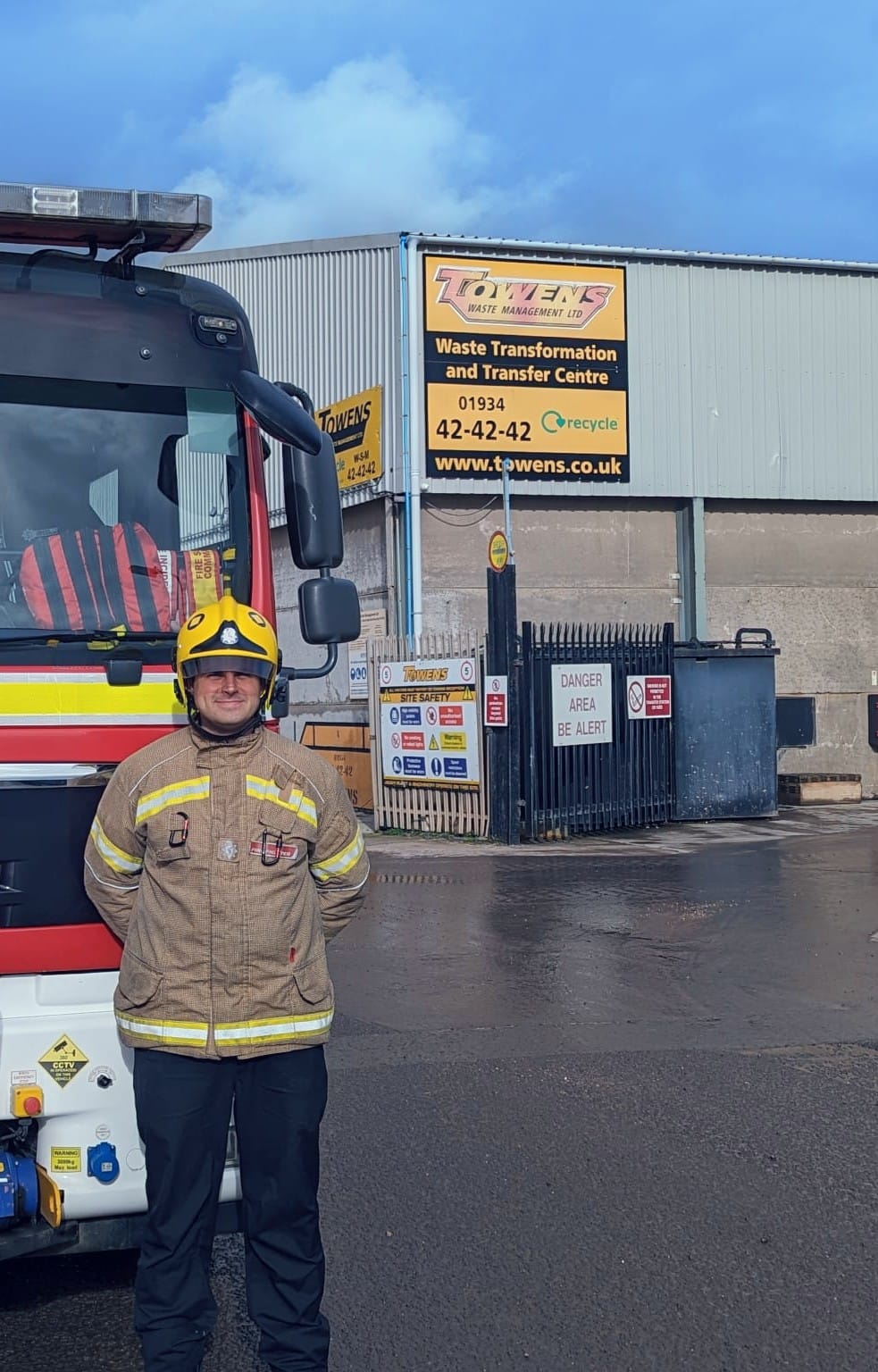 Firefighter in full gear standing in front of a fire engine outside Towens Waste Transformation and Transfer Centre in Somerset.